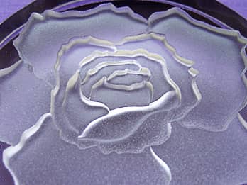 ガラス製ペーパーウェイトに彫刻したバラの花のクローズアップ画像