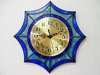 時計針の軸を中心にして、ステンドグラス部を少しだけ回して固定した場合のステンドグラス製の掛け時計 ブルー