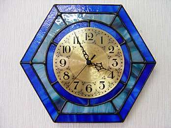 時計針の軸を中心にして、六角形のステンドグラス部を少しだけ回して固定した場合のステンドグラス製のインテリアクロック ブルー（六角形）