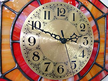 ステンドグラス製の掛け時計 オレンジ（六角形）の文字盤と針のクローズアップ画像