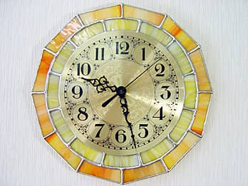時計針の軸を中心にして、十二角形のステンドグラス部を少しだけ回して固定した場合のステンドグラス製の掛け時計 レモンイエロー