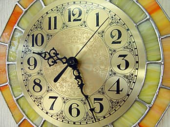 ステンドグラス製の掛け時計 レモンイエローの文字盤と針のクローズアップ画像