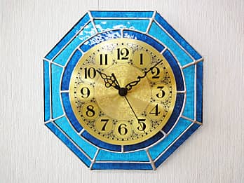 ブルーのステンドグラスで装飾した八角形の掛け時計