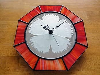 ナデシコを彫刻した鏡と、赤色のステンドグラスで作った八角形の掛け時計