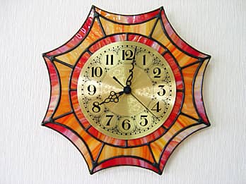 時計針の軸を中心にして、ステンドグラス部を少しだけ回して固定した場合のステンドグラス時計 オレンジ