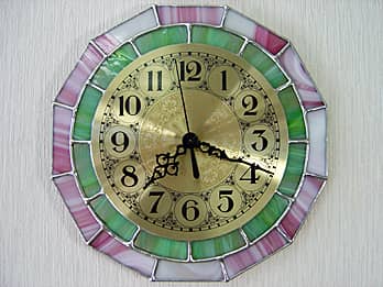 時計針の軸を中心にして、十二角形のステンドグラス部を少しだけ回して固定した場合のステンドグラス製のインテリアクロック ローズピンク