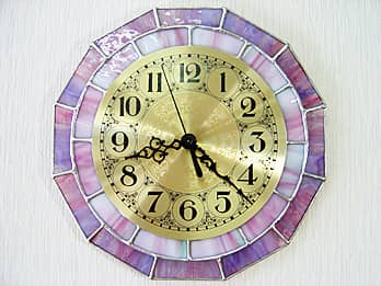 紫色とピンク色のステンドグラスピースで装飾した十二角形の掛け時計